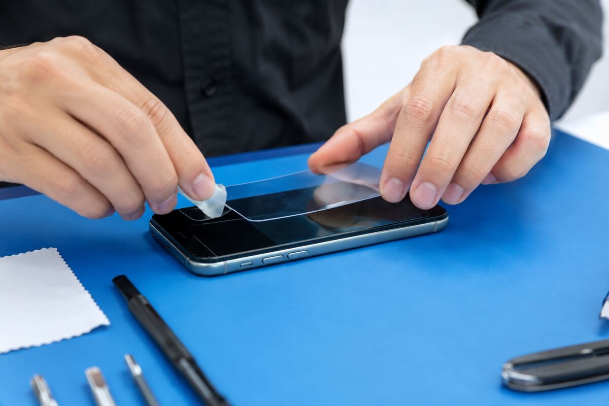 スマートフォンへコーティングと保護フィルムを施工する様子
